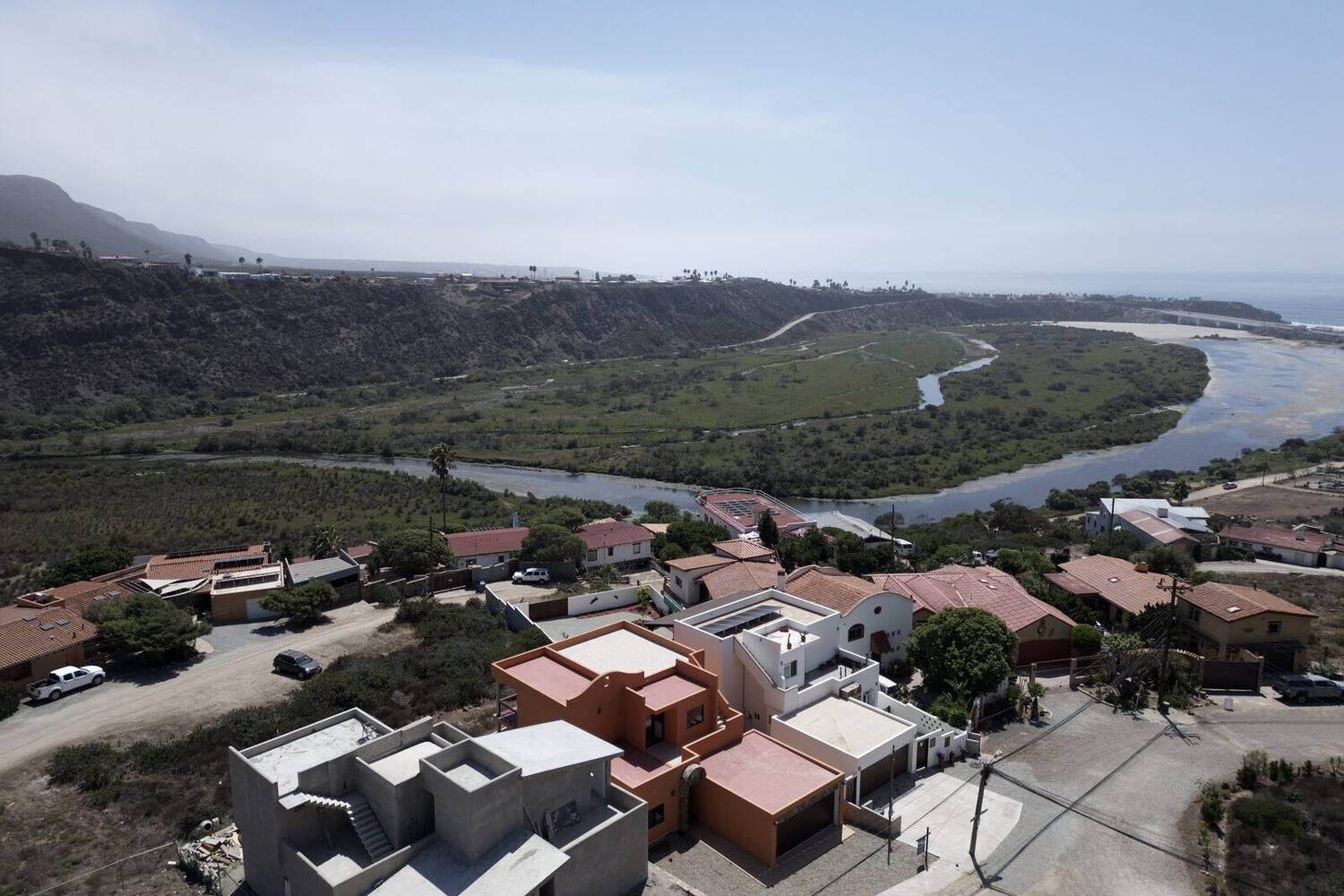 Aerial of the house above the open land, the river estuary and the ocean beyond