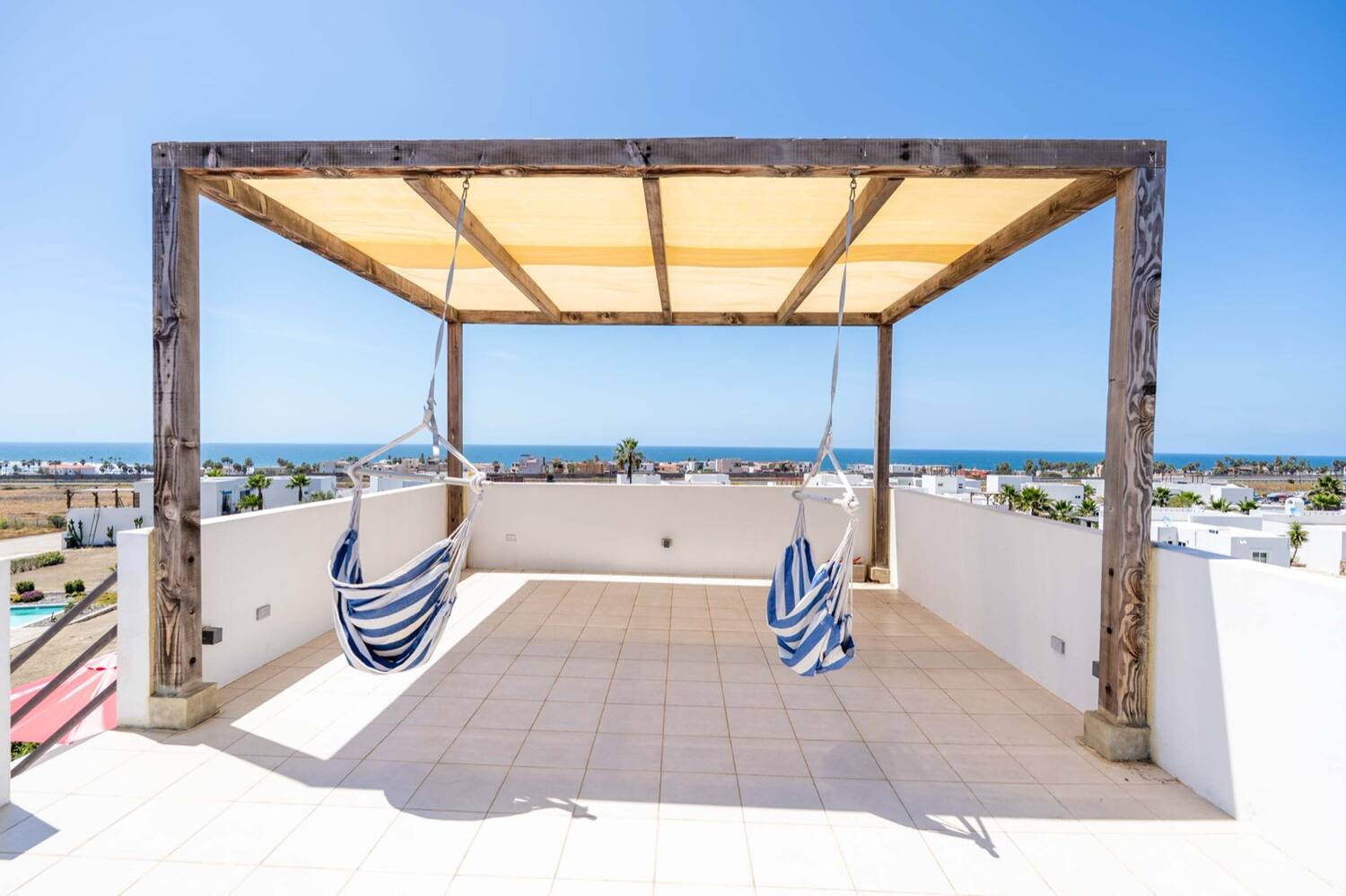Rooftop deck with pergola and hanging chairs above the community